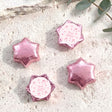 Pink foil-covered chocolate stars with personalised party label on pink insert