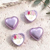 Heart-shaped foil-covered chocolate hearts in lilac and purple, with floral center labels