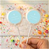 Two pastel blue confirmation lollipops with white cross labels, clear wrappers, sticks