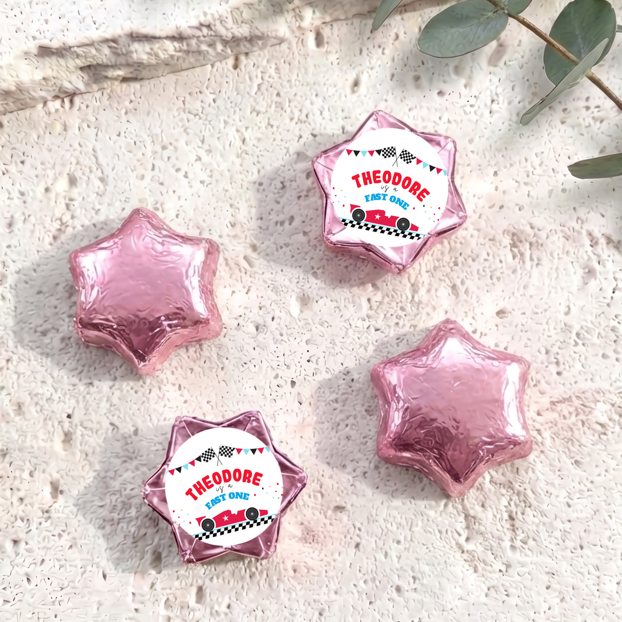 Personalised foil chocolate star set with pink-purple foil and “THEODORE” label