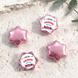 Personalised foil chocolate star set with pink-purple foil and “THEODORE” label
