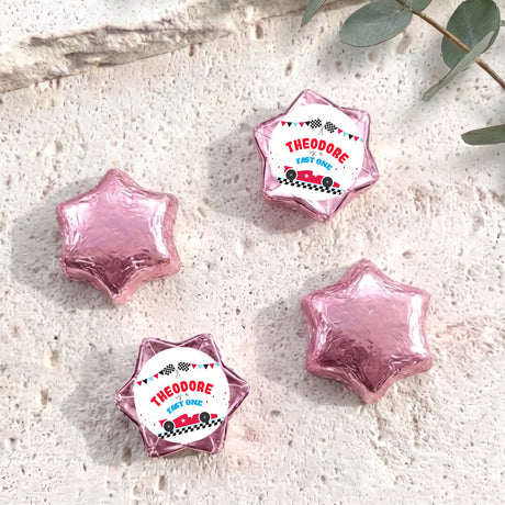 Pink foil-covered chocolate star sweets with personalized "THEODORE" label