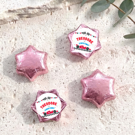 Pink foil-covered star chocolates with personalised label wrappers, four pieces shown