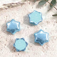 Blue foil-wrapped chocolate stars with cross and light blue personalised label