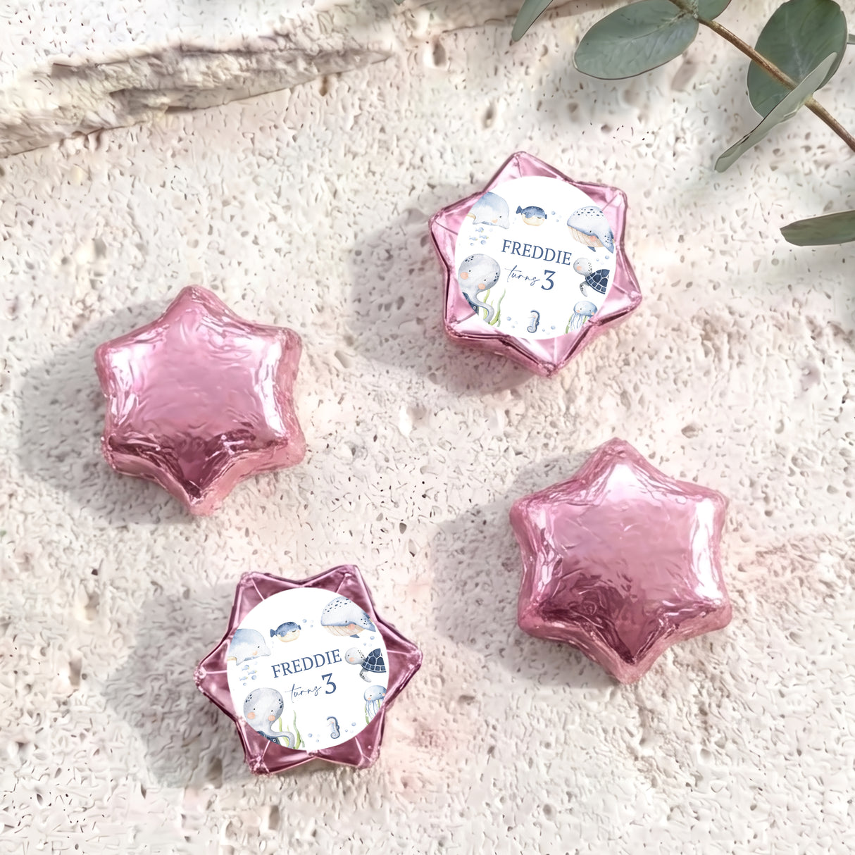 Pink foil-covered star chocolates with 'Freddie 3' label, five pieces