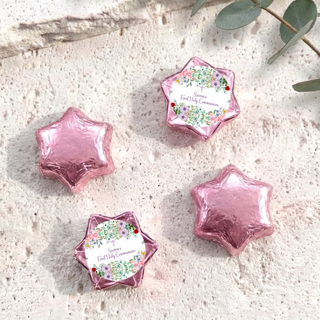 Pink foil-covered First Holy Communion chocolate stars with floral personalised labels