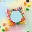 Pastel blue cross jelly bean bags, clear pouches with assorted colorful jelly beans