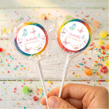 Personalised lollipops: two pastel butterfly round labels on sticks with rainbow edging.