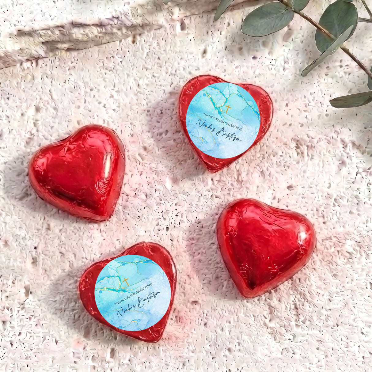 Red foil heart chocolates for baptism, with light blue label and gold cross print