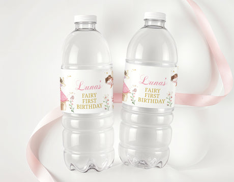Personalized fairy first birthday water bottle labels on two clear plastic bottles