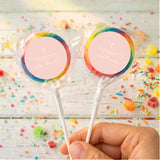 Personalised cross lollipops with rainbow wrap, round personalised label, held in hand