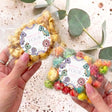 Personalised dinosaur popcorn bags, “Dolly is Four” on circular label, clear treat pouches