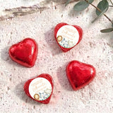 Red foil-covered chocolate heart with round Christening label and baby animals