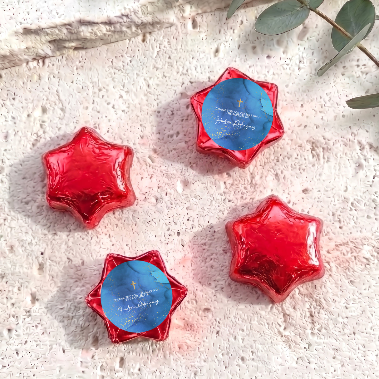 Personalised foil-covered chocolate stars in red and blue, with gold cross and text