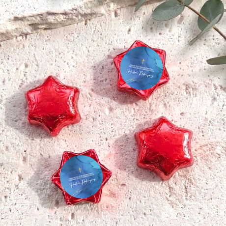 Red foil chocolate stars with blue personalised circle label and gold cross