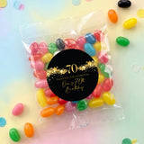 Clear jelly bean bag with black round '70th' design, gold stars and candy inside