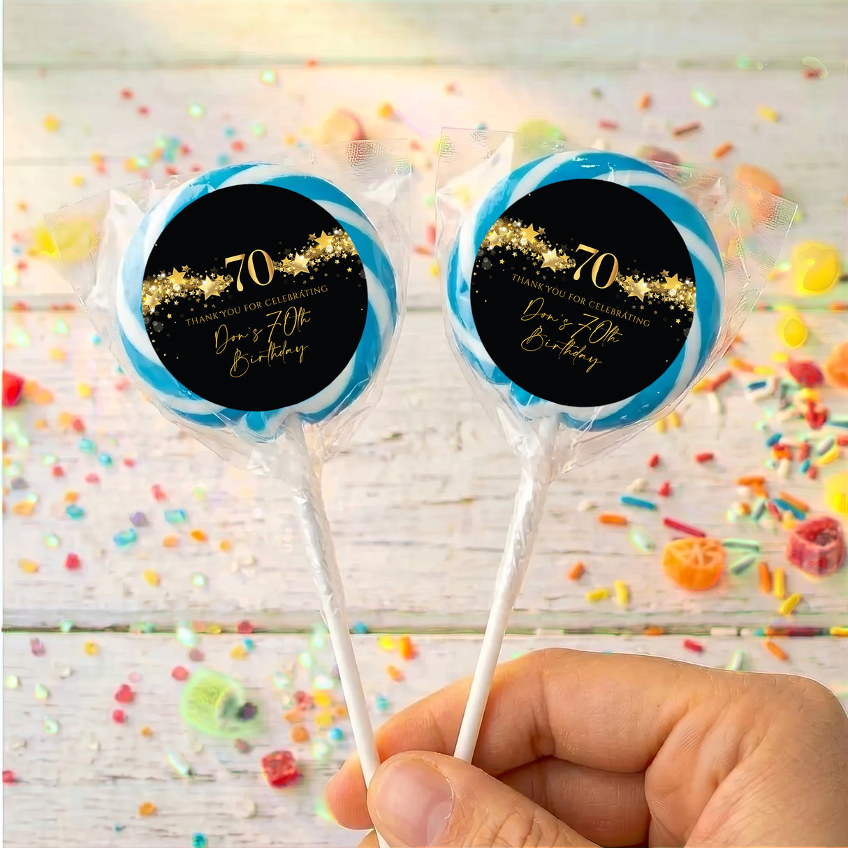 70th birthday personalised lollipops, black gold 70 label with blue ring, clear wrap.