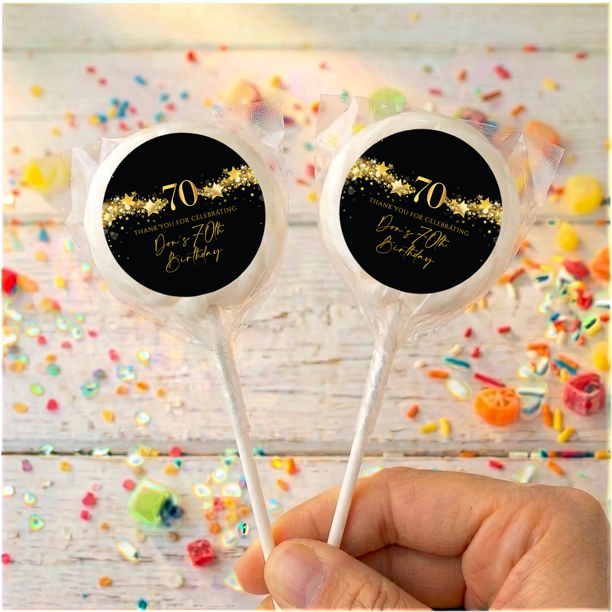 70th birthday personalised lollipops, black with gold 70 star label on clear wrap.