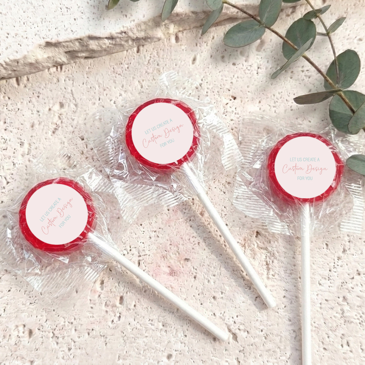 Mini lollipops with red lollipop tops, wrapped in clear plastic on white sticks.