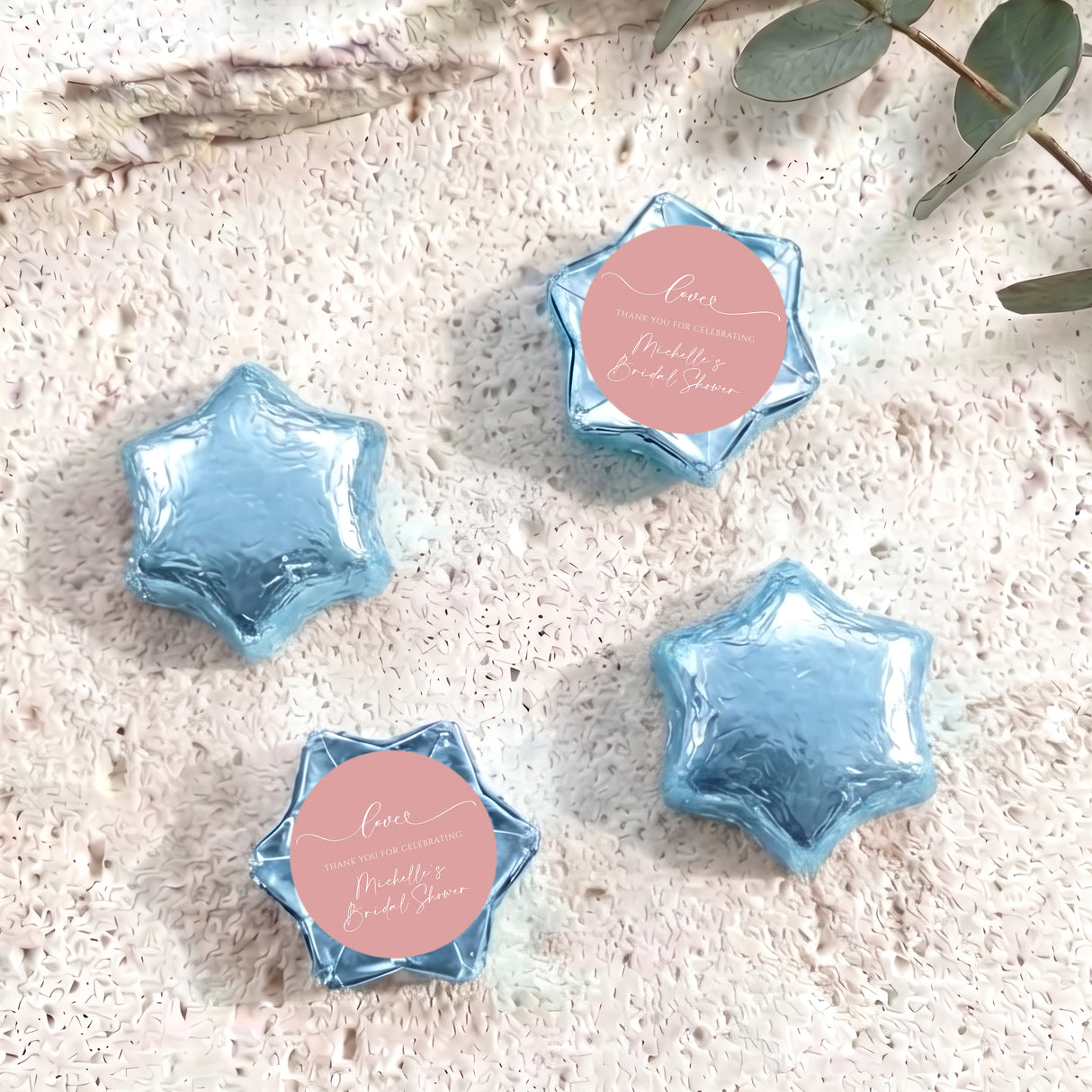 Set of light blue foil-covered chocolate stars with pink heart labels