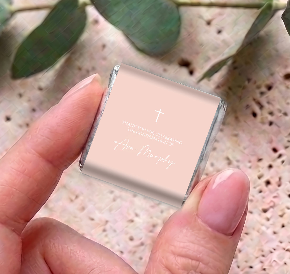 Pastel peach mini chocolate with white cross and thank-you confirmation message, held up