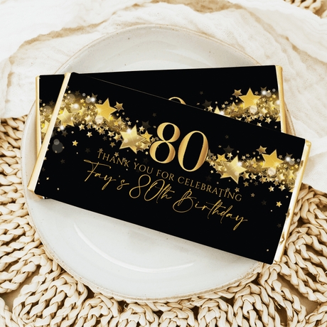 Black chocolate bar wrapper with gold 80, stars, and Thank you for celebrating text