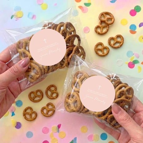 Personalised pretzel bags with pretzels in clear wrapping, round tags with cross.