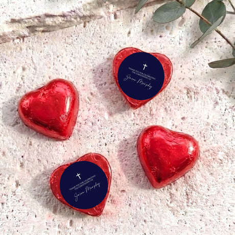 Foil-covered chocolate hearts, red metallic with navy label and cross