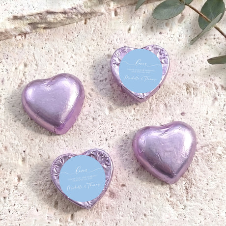 Purple foil heart chocolate favors with round blue personalised label