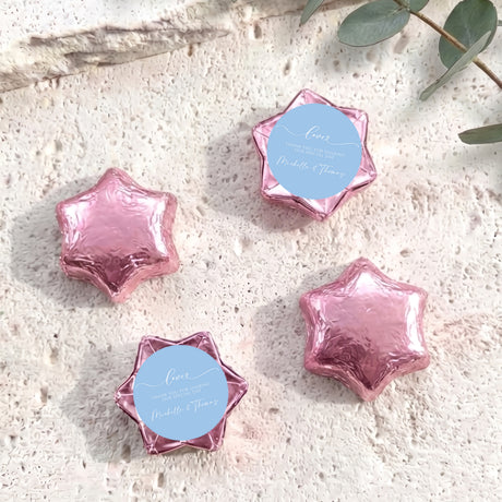 Pink foil-wrapped chocolate stars with round personalized label discs