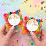 Two personalized jelly bean bags, each with round floral label, held in hands