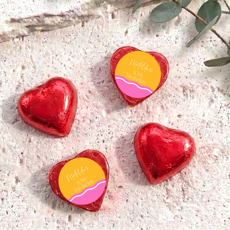 Red foil-covered chocolate heart chocolates with personalised birthday label on top