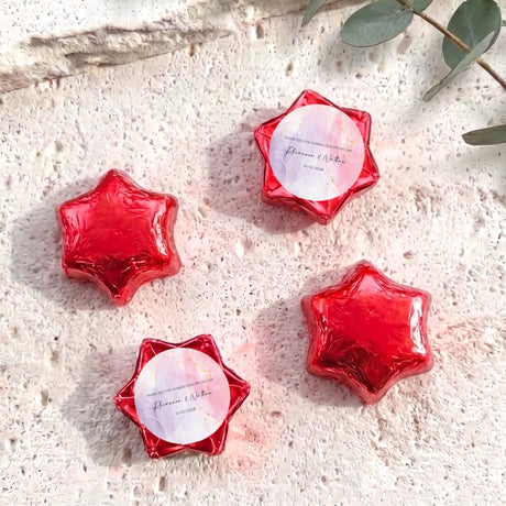 Red foil star chocolates with circular personalized label in star-shaped wrapper