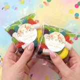Two clear lolly bags of mixed candies, each with round floral personalised thank-you label