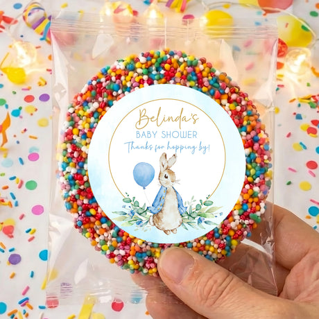 Clear bag of rainbow sprinkles with round baby shower label and rabbit illustration