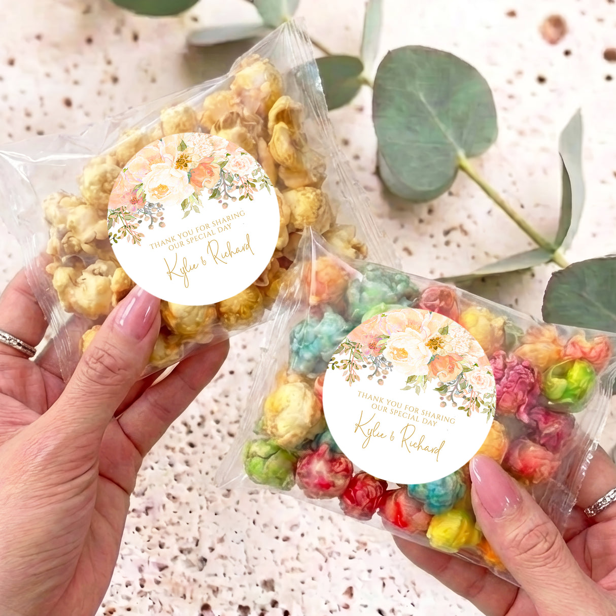 Personalised popcorn bag with clear wrapper and round floral label, pastel rainbow popcorn
