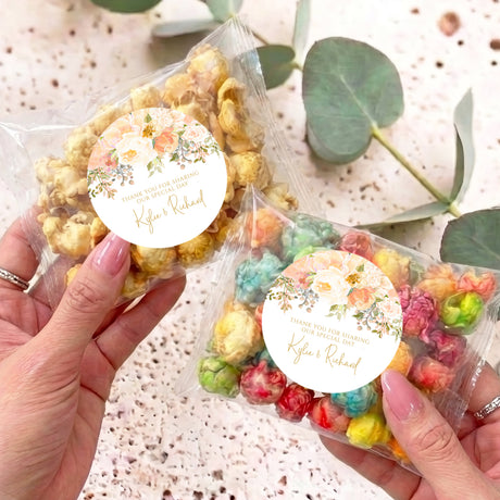 Personalised popcorn bag with clear wrapper and round floral label, pastel rainbow popcorn
