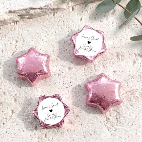 Pink foil chocolate stars with round bridal shower label and black heart design