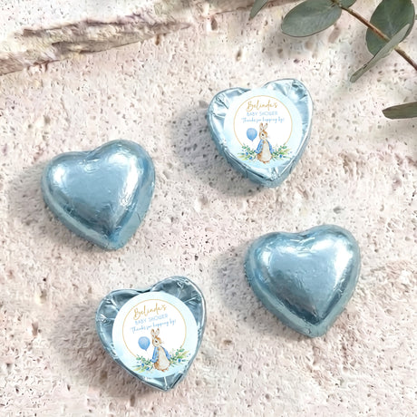 Blue foil-covered chocolate heart with baby shower label featuring a bunny illustration