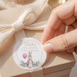 Round printed first birthday label with Peter Rabbit in pink floral design