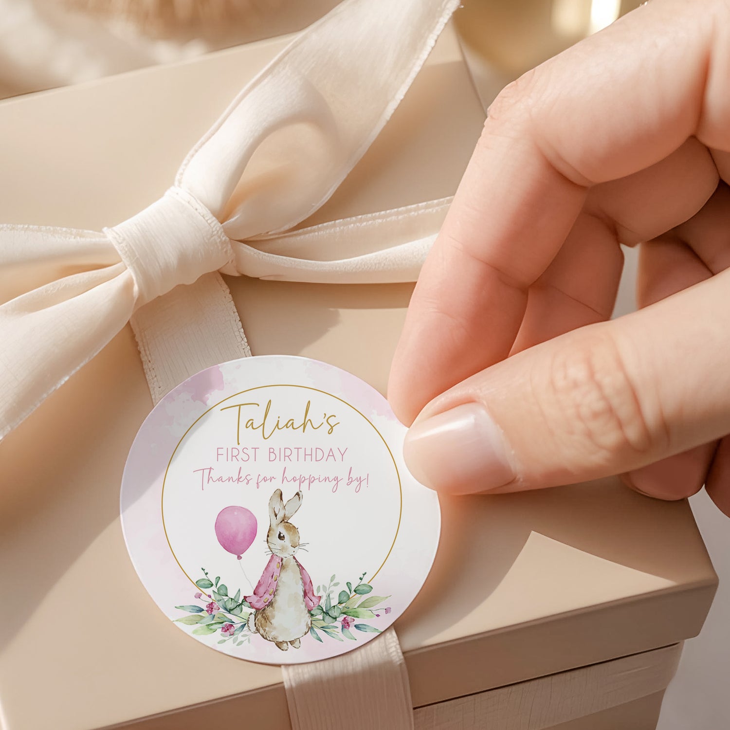 Round printed first birthday label with Peter Rabbit in pink floral design