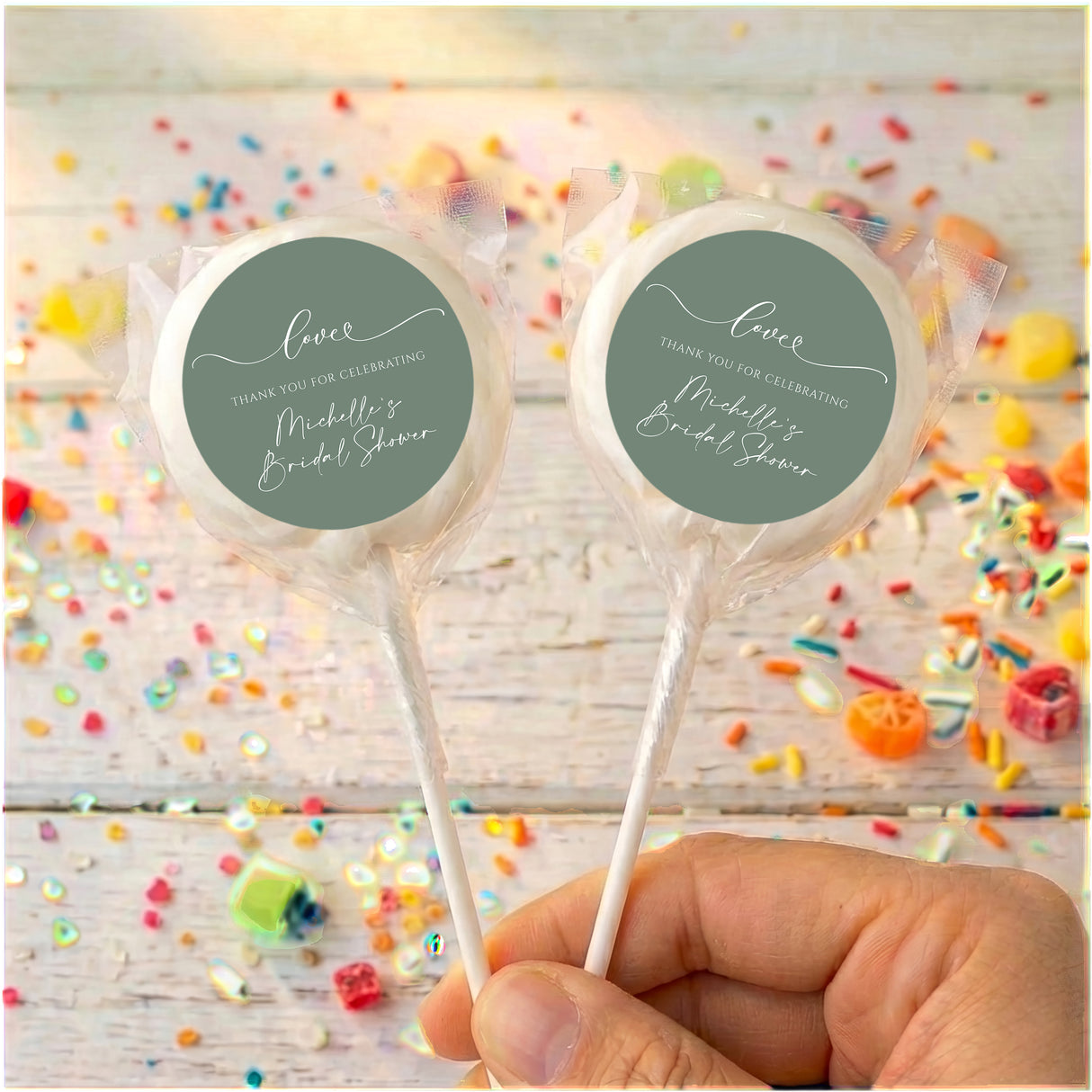 Personalised wrapped lollipops with round sage-green labels on white sticks