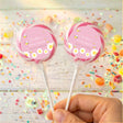 Pink baby shower lollipops with bee design, two wrapped pops with pink circle labels