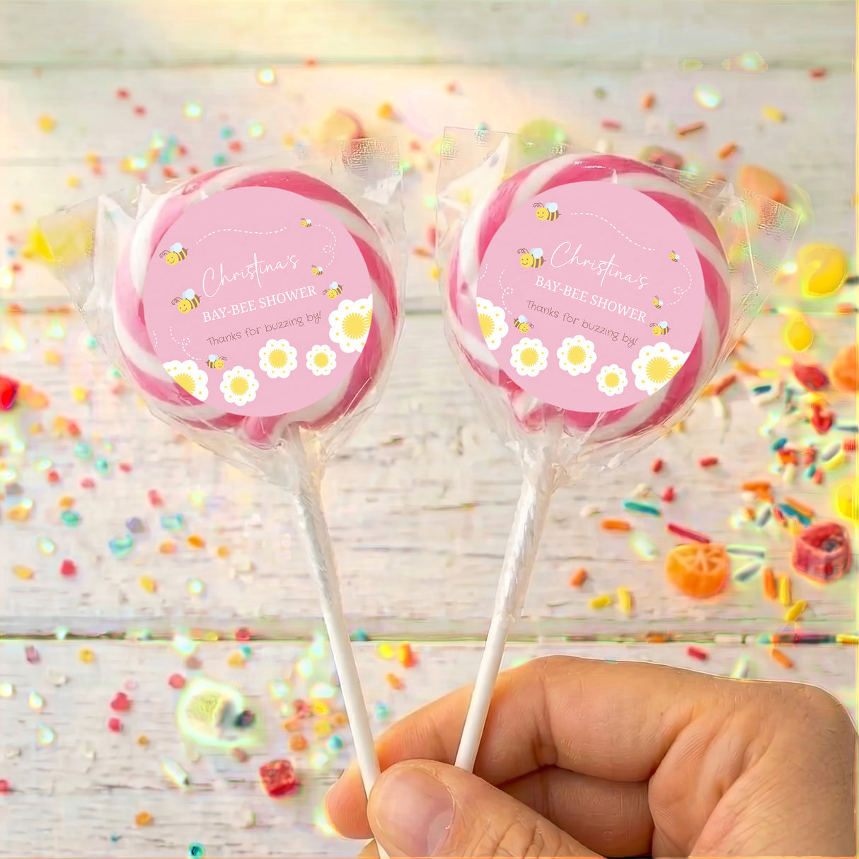 Pink baby shower lollipops with bee design, two wrapped pops with pink circle labels