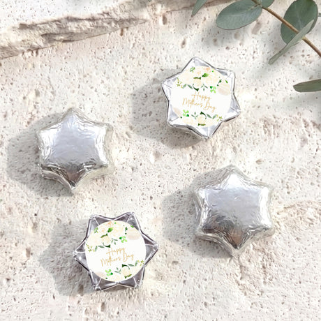 Silver foil-covered chocolate stars with a round personalized label on each piece