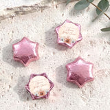 Pink foil-covered chocolate stars with floral bridal shower message labels