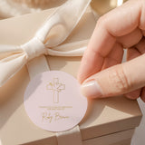 Round pink baptism favor label with dove and cross; thank-you text and name Ruby Brown