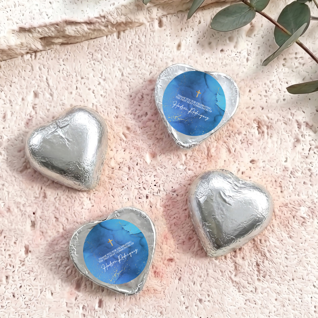 Foil-covered chocolate hearts with silver wrappers and gold cross design