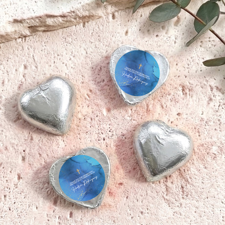 Foil-covered chocolate hearts with silver wrappers and gold cross design