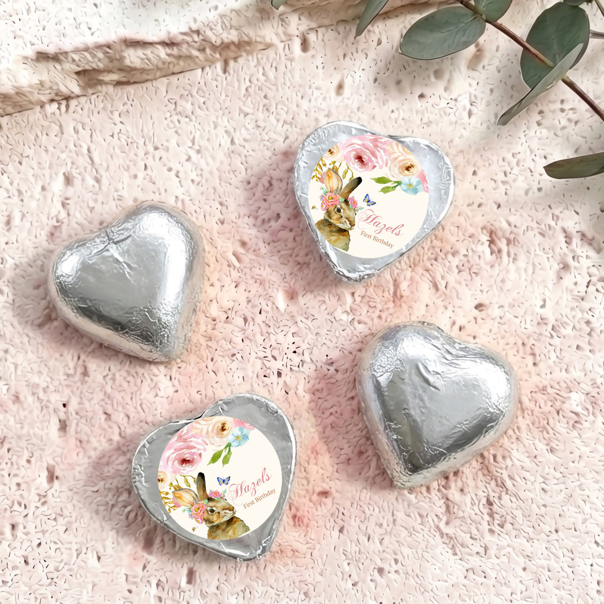Silver foil-covered chocolate hearts with floral wrapped center medallions
